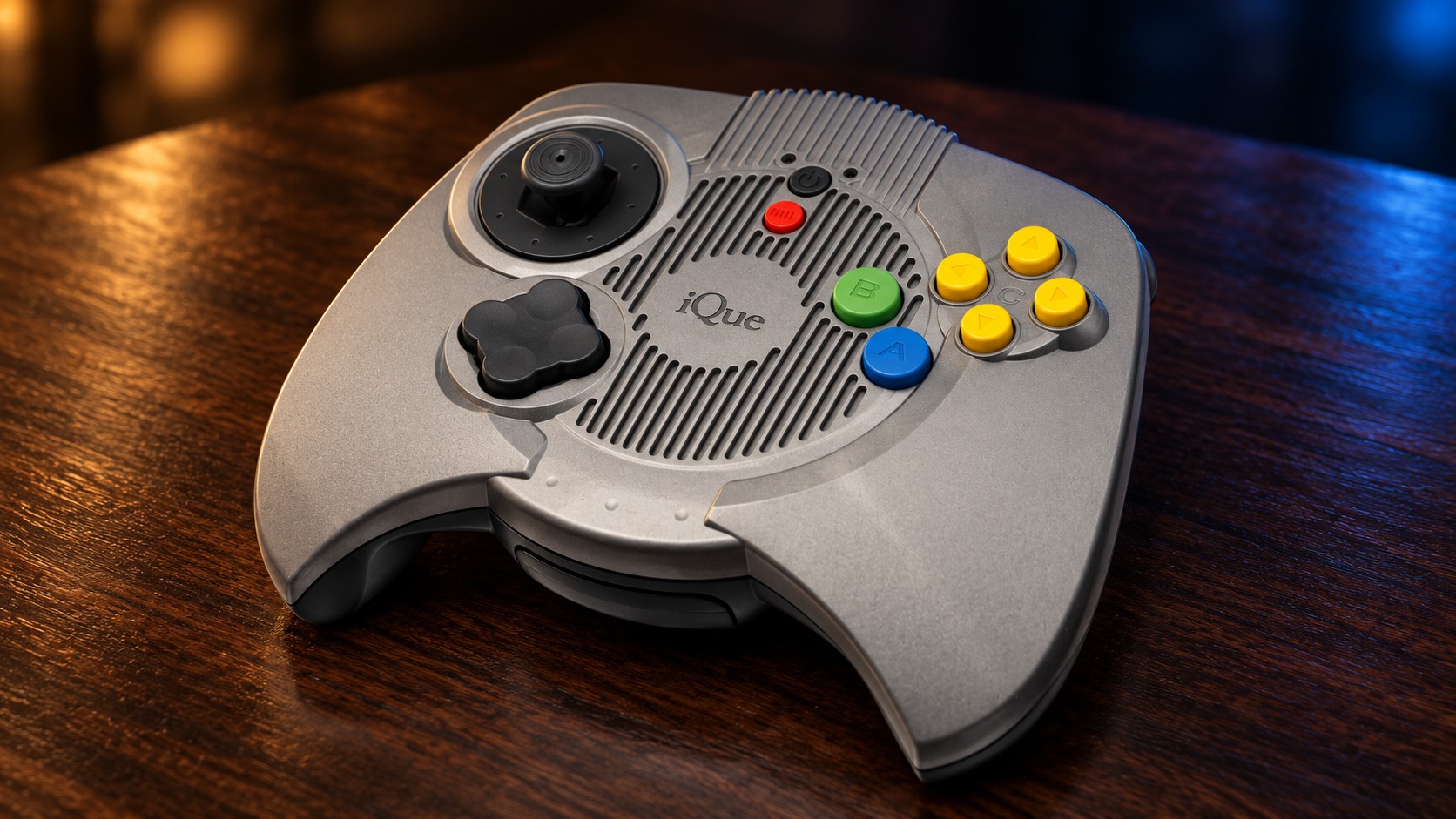 iQue Player mit passendem Controller auf einem dunklen Holztisch vor dezent beleuchtetem Hintergrund